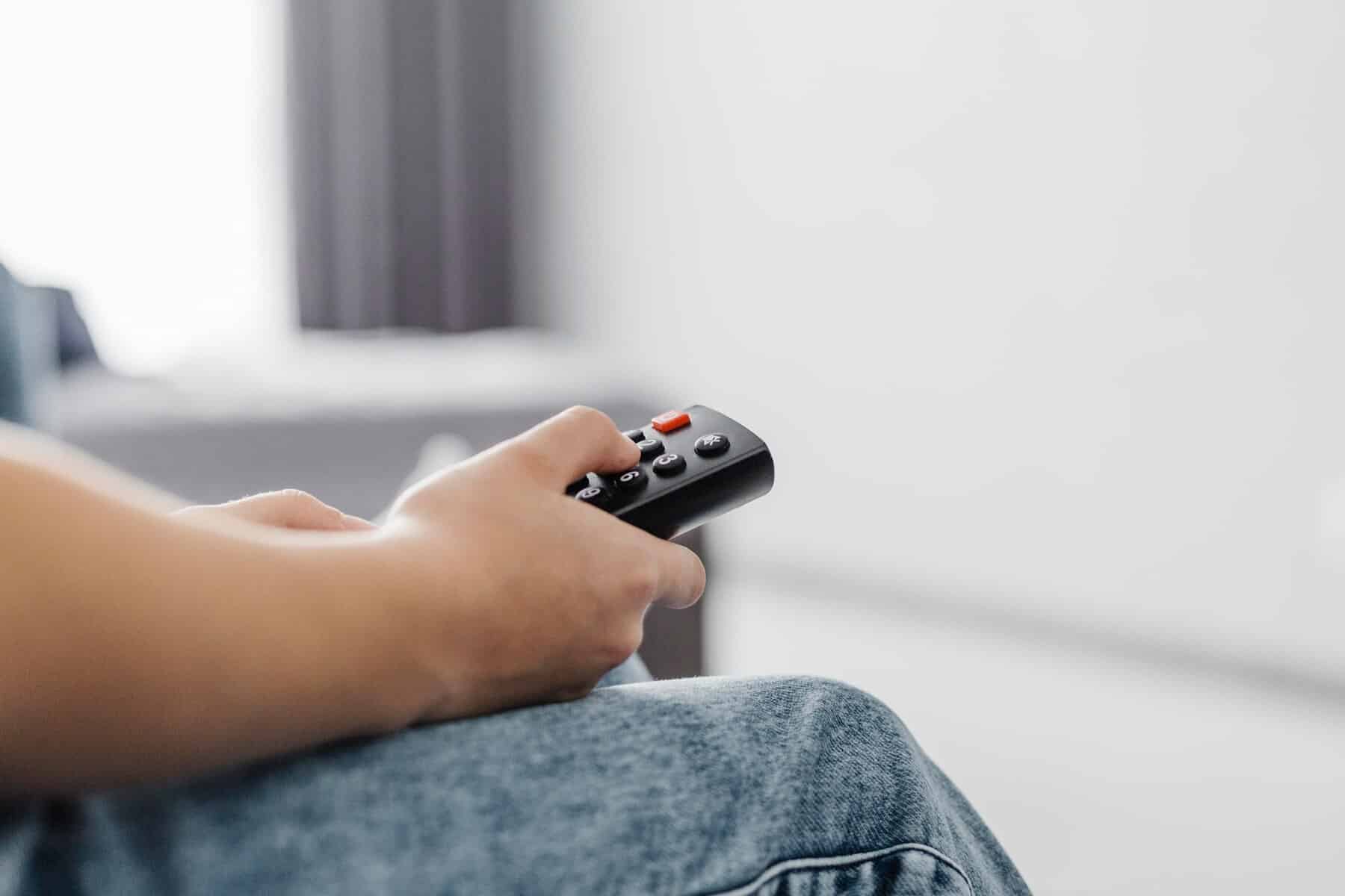 Close up person using television remote