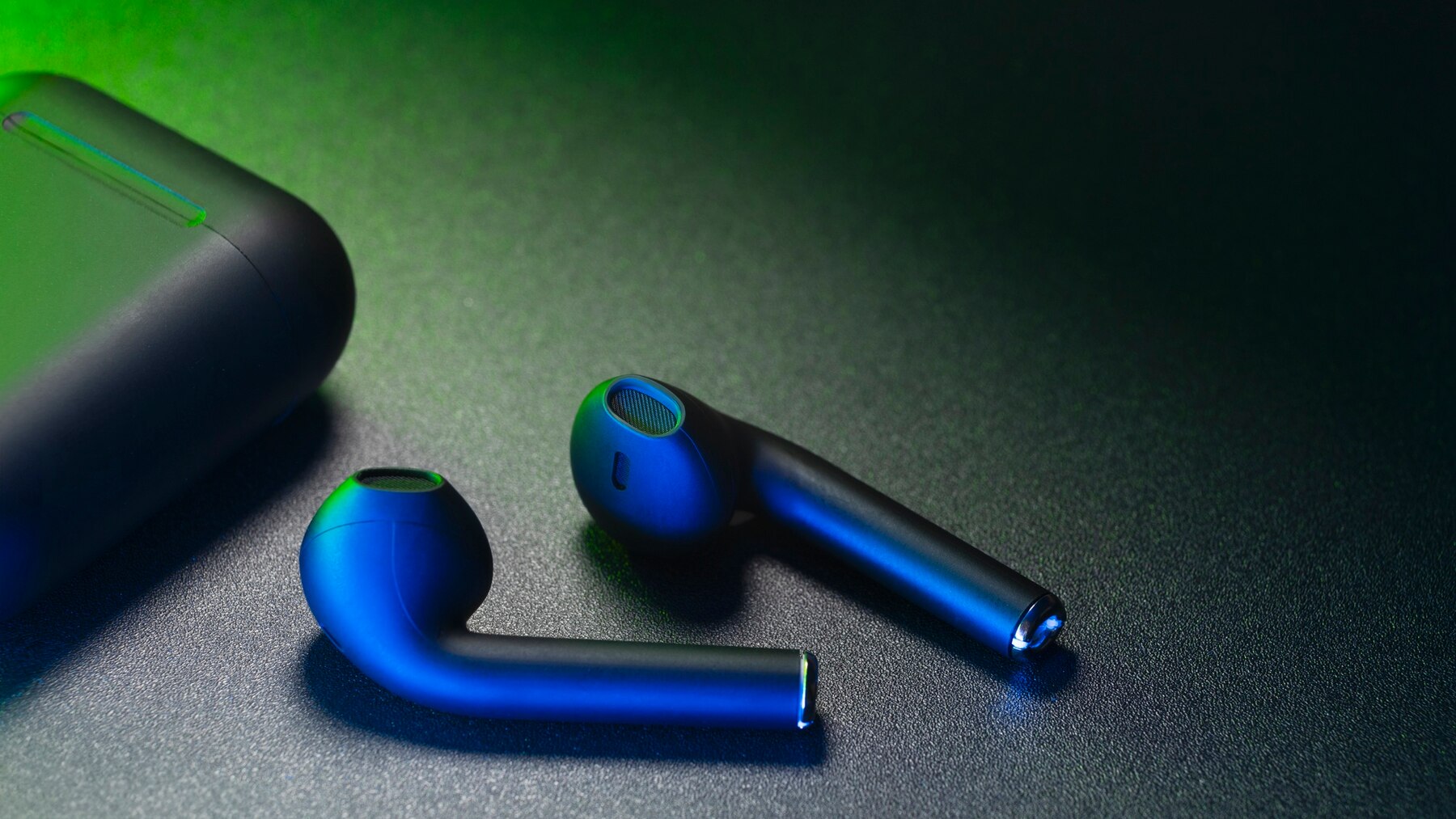 Close-up of blue wireless earbuds next to their charging case, set against a dark, gradient background.