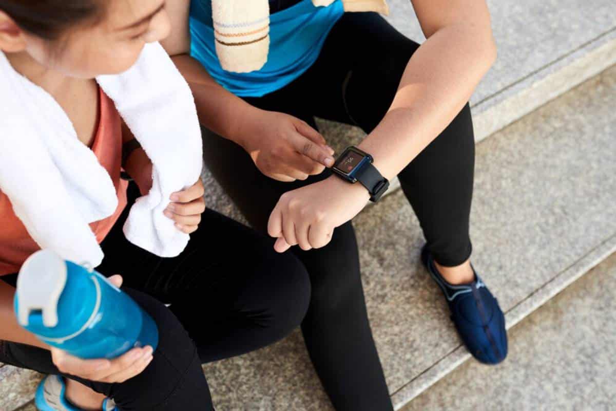 while touching another person's wrist, highlighting smartwatch functionality and interaction.