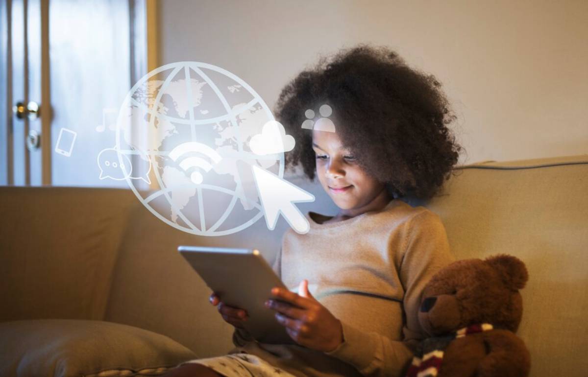 A child seated on a couch, engrossed in a tablet