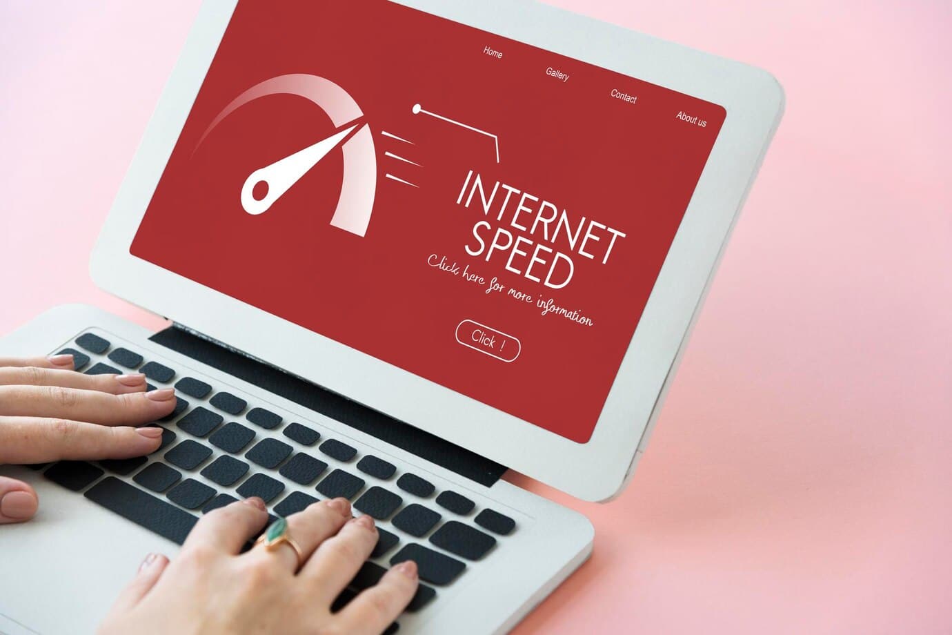 A person’s hands typing on a laptop displaying a dashboard for checking internet speed with a red background.